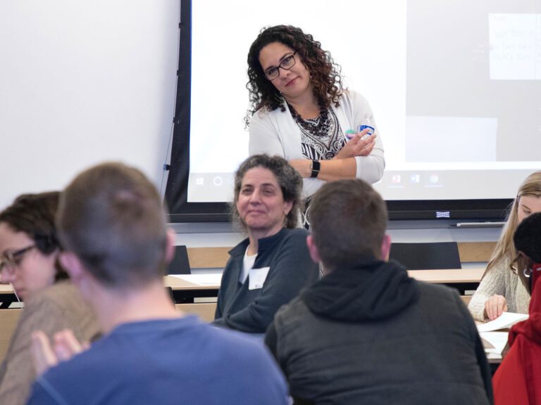 Dr. Ralina Joseph smiling in front of an Interrupting Privilege class